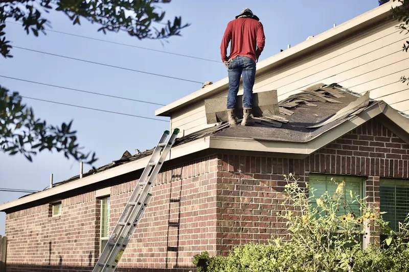 Professional roofer working on a residential roof in Louisburg